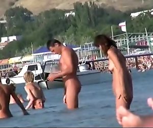 Nudist girls have fun with each other at the beach
